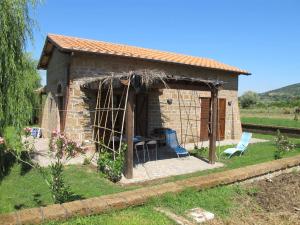 een klein stenen huis met 2 stoelen en een tafel bij Apartment Casa Alessandro n-5 by Interhome in Montefiascone