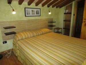 een slaapkamer met een bed met een gestreepte sprei bij Apartment Casa Alessandro n-5 by Interhome in Montefiascone +45 foto's