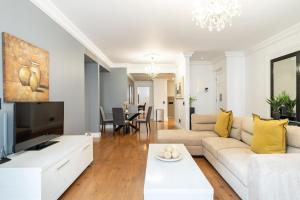 a living room with a couch and a tv at Cape Royale Elegance & Comfort in Cape Town