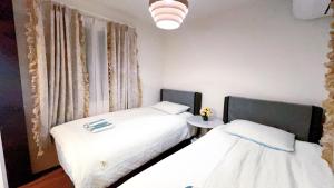 two twin beds in a room with a window at Tokyo Hoshino House 1Floor in Tokyo