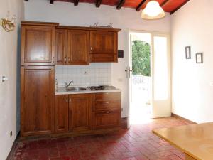 una cucina con mobili in legno e un lavello di Apartment Fattoria Petraglia - Terrazza by Interhome a Monteriggioni