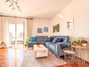 ein Wohnzimmer mit einem blauen Sofa und einem Tisch in der Unterkunft Apartment Ana-1 by Interhome in Turanj