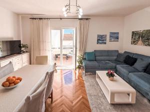 ein Wohnzimmer mit einem blauen Sofa und einem Tisch in der Unterkunft Apartment Ana-1 by Interhome in Turanj + 21 Fotos