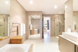 a bathroom with two sinks and a shower and a tub at Cape Royale Elegance & Comfort in Cape Town +23 photos