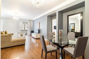 a dining room and living room with a table and chairs at Cape Royale Elegance & Comfort in Cape Town