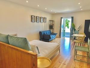 ein Wohnzimmer mit einer Couch und einem Sessel in der Unterkunft Espada Preta Apartments in Câmara de Lobos