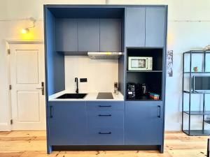 eine Küche mit blauen Schränken und einer Spüle in der Unterkunft Espada Preta Apartments in Câmara de Lobos