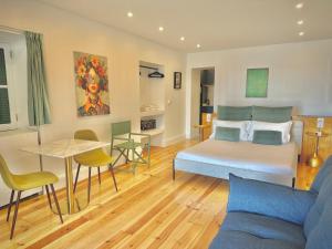 ein Schlafzimmer mit einem Bett, einem Tisch und einer Couch in der Unterkunft Espada Preta Apartments in Câmara de Lobos