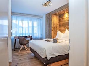 een slaapkamer met een bed en een bureau met een stoel bij Apartment Chesa Fleury by Interhome in St. Moritz