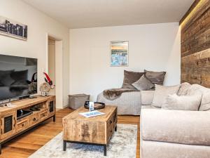 een woonkamer met een bank en een tv bij Apartment Chesa Fleury by Interhome in St. Moritz +19 foto's