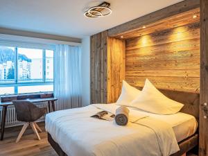 a bedroom with a large bed with a wooden wall at Apartment Chesa Fleury by Interhome in St. Moritz
