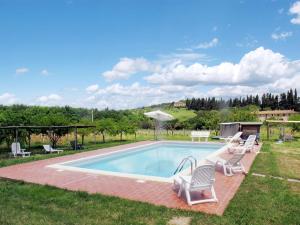 una piscina con due sedie e un tavolo di Apartment Fattoria Petraglia - Loggiato by Interhome a Monteriggioni
