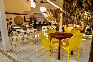 ein Restaurant mit gelben Stühlen und einem Tisch mit Stühlen in der Unterkunft Reserva do Paiva suites in Cabo de Santo Agostinho