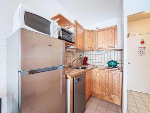 een keuken met een roestvrijstalen koelkast en een magnetron bij Studio Cosmos-1 by Interhome in Le Corbier