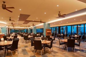 a restaurant with tables and chairs and windows at Sheraton Okinawa Sunmarina Resort in Onna