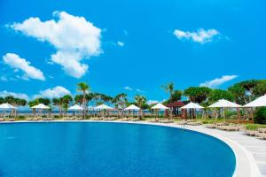 a resort swimming pool with chairs and umbrellas at Sheraton Okinawa Sunmarina Resort in Onna