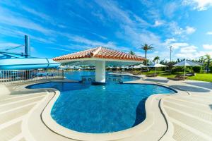 a swimming pool with an umbrella in a resort at Sheraton Okinawa Sunmarina Resort in Onna