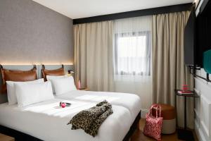 een groot wit bed in een kamer met een raam bij Moxy Paris La Villette in Parijs +38 foto's