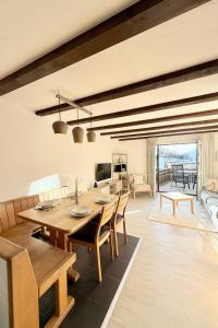 a dining room with a table and chairs and a living room at Apartment Residenza Chesa Margun 58-5 by Interhome in Surlej
