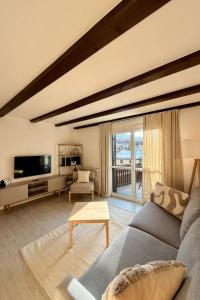 a living room with a couch and a tv at Apartment Residenza Chesa Margun 58-5 by Interhome in Surlej