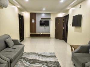 a living room with a couch and a flat screen tv at فندق جراند روز in Najran