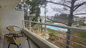 een balkon met twee stoelen en uitzicht op de oceaan bij Oceana Suites El Tabo in El Tabo