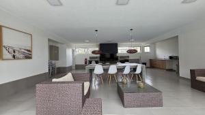 een woonkamer met een tafel en witte stoelen bij Oceana Suites El Tabo in El Tabo