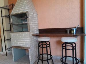 a brick oven with two stools in front of it at Hostel Peró Cabo Frio in Cabo Frio