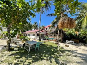 a table and chairs in front of a house at Casa Alegria Beach Rooms in Alegria