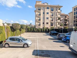 ein Parkplatz mit vor einem Gebäude geparkten Autos in der Unterkunft Apartment Celio I by Interhome in Albir