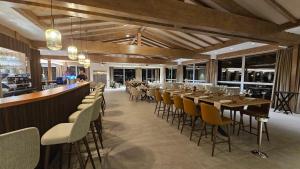 a restaurant with a long bar with tables and chairs at Domaine Le H in Munster