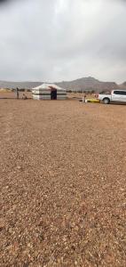 a parking lot with cars parked in the desert at مخيم السراي الشتوي in ‘Ibrī