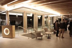 een lobby met stoelen en een podium in een gebouw bij Domaine Le H in Hohrod