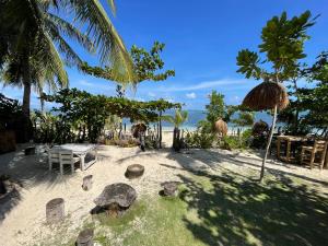 a beach with a table and chairs and the ocean at Casa Alegria Beach Rooms in Alegria
