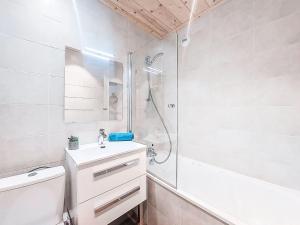 een witte badkamer met een wastafel en een douche bij Studio Cosmos-7 by Interhome in Le Corbier