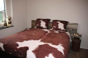 una camera da letto con un letto marrone e bianco con una finestra di Bed and Breakfast Reestdal a Meppel