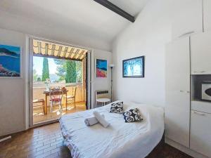 une chambre avec un lit et un balcon avec une table dans l'établissement Studio Les Hauts du Port-1 by Interhome, à Saint-Cyr-sur-Mer