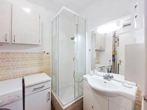 une salle de bain blanche avec une douche et un lavabo dans l'établissement Studio Les Hauts du Port-1 by Interhome, à Saint-Cyr-sur-Mer