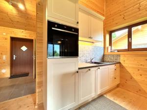 a kitchen with white cabinets and a sink at Chalet Chalet Stressless I by Interhome in Presseggen +17 photos