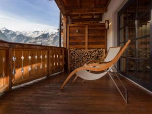 a chair on a balcony with a view of mountains at Apartment Mountain Resort C15 by Interhome in Kaprun