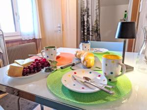 a table with plates of food and cups and bread at Apartment Vreneli by Interhome in Lauterbrunnen