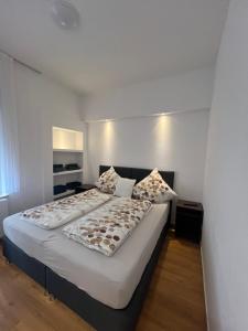 ein Schlafzimmer mit einem großen Bett mit weißen Wänden in der Unterkunft Pension Zwei A Altstadt in Leverkusen