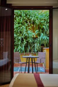a table and chairs in a room with a plant wall at Boutique Hostemplo Sagrada Familia in Barcelona