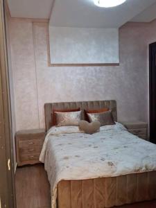 Una mujer acostada en una cama en un dormitorio. en Résidence Al Hayat Agadir, en Aourir