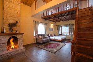 een woonkamer met een open haard en een trap bij Indulge Ramgarh by PACK in Rāmgarh