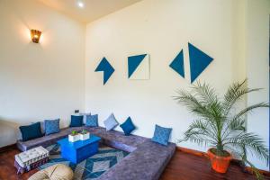een woonkamer met een bank en pijlen op de muur bij Indulge Ramgarh by PACK in Rāmgarh