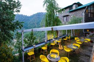 een patio met gele stoelen en tafels en een gebouw bij Indulge Ramgarh by PACK in Rāmgarh