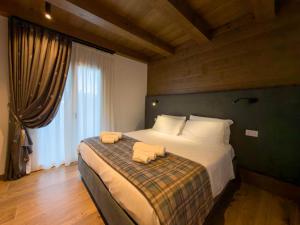 ein Schlafzimmer mit einem großen Bett mit zwei Handtüchern darauf in der Unterkunft Luxury Mountain Suites in Roccaraso