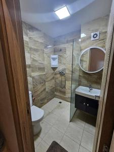 Un baño con inodoro, lavabo y espejo. en Résidence Al Hayat Agadir, en Aourir