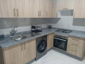 una cocina con fregadero y lavadora en Résidence Al Hayat Agadir, en Aourir